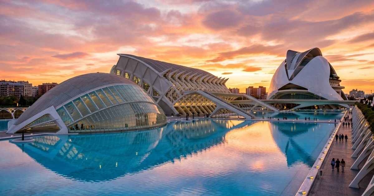 Modern white buildings and reflecting pools at the City of Arts and Sciences complex in Valencia at sunset.