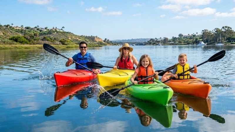 People kayaking on the calm waters of Agua Hedionda Lagoon in Carlsbad California.