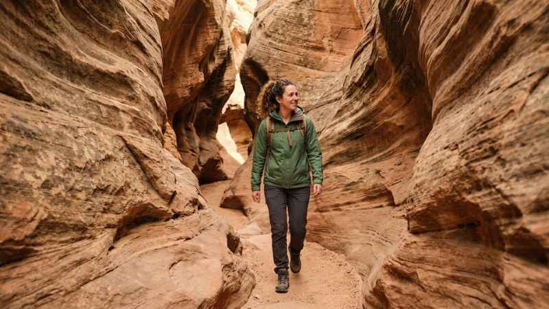 Hiker walking through the narrow sandstone walls of Annie's Canyon in Solana Beach