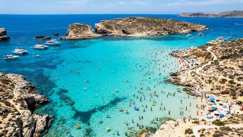 Crystal clear turquoise water and swimmers at the Blue Lagoon in Comino Malta