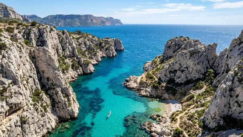 Dramatic limestone cliffs and turquoise water at Calanques National Park near Marseille.