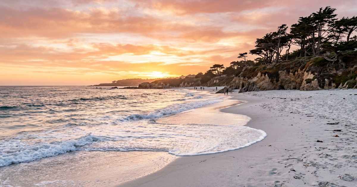 Sunset view of white sand and waves at Carmel Beach in Carmel-by-the-Sea, California.