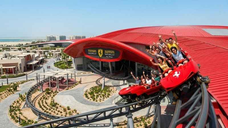 Red roller coaster tracks and guests enjoying Ferrari World on Yas Island