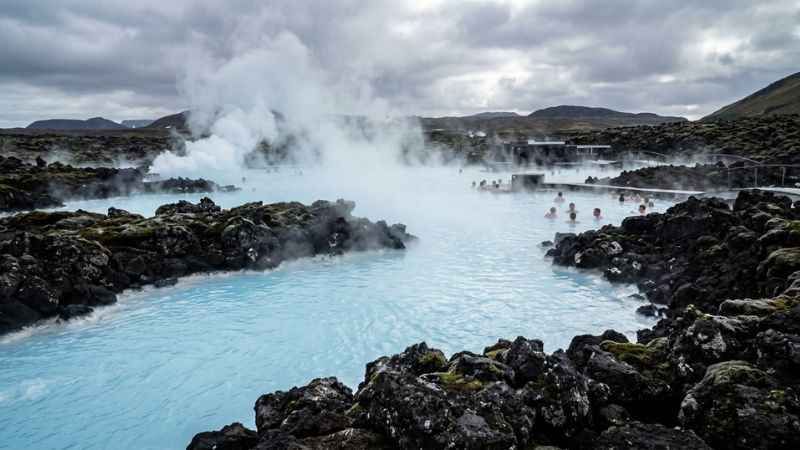 Visitors relaxing in the warm milky-blue geothermal waters of the Blue Lagoon in Iceland.