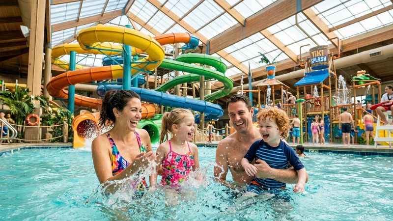 Family enjoying indoor water park slides and pools in the Poconos.