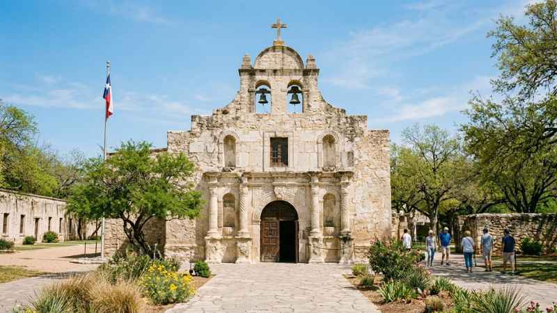 Front facade of the historic Alamo chapel under a clear blue sky in downtown San Antonio
