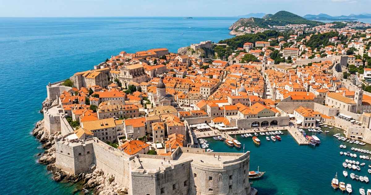 Aerial view of Dubrovnik Old Town terracotta rooftops and the Adriatic Sea.