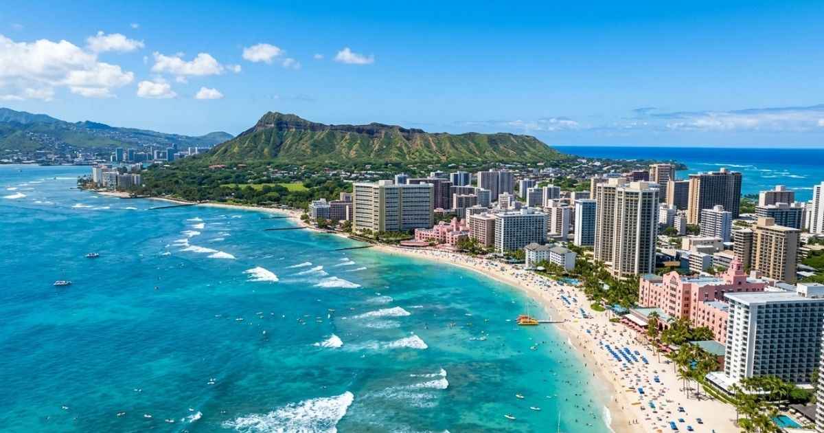 Aerial view of Waikiki Beach and Diamond Head crater on a sunny day in Oahu.