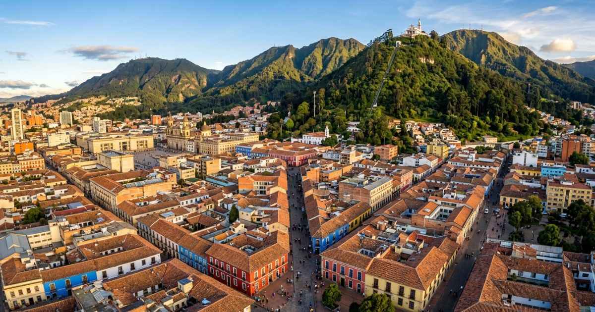 Aerial view of colorful colonial rooftops in La Candelaria with Cerro de Monserrate in the background in Bogotá, Colombia.