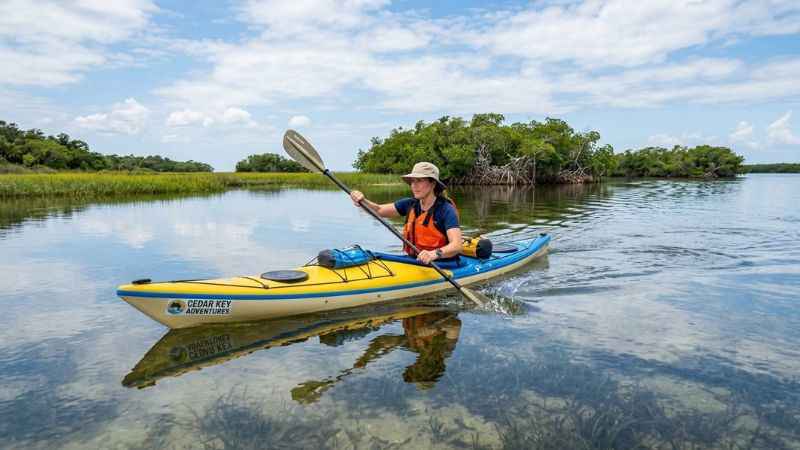 Kayaker paddling in coastal waters near Cedar Key, Florida.