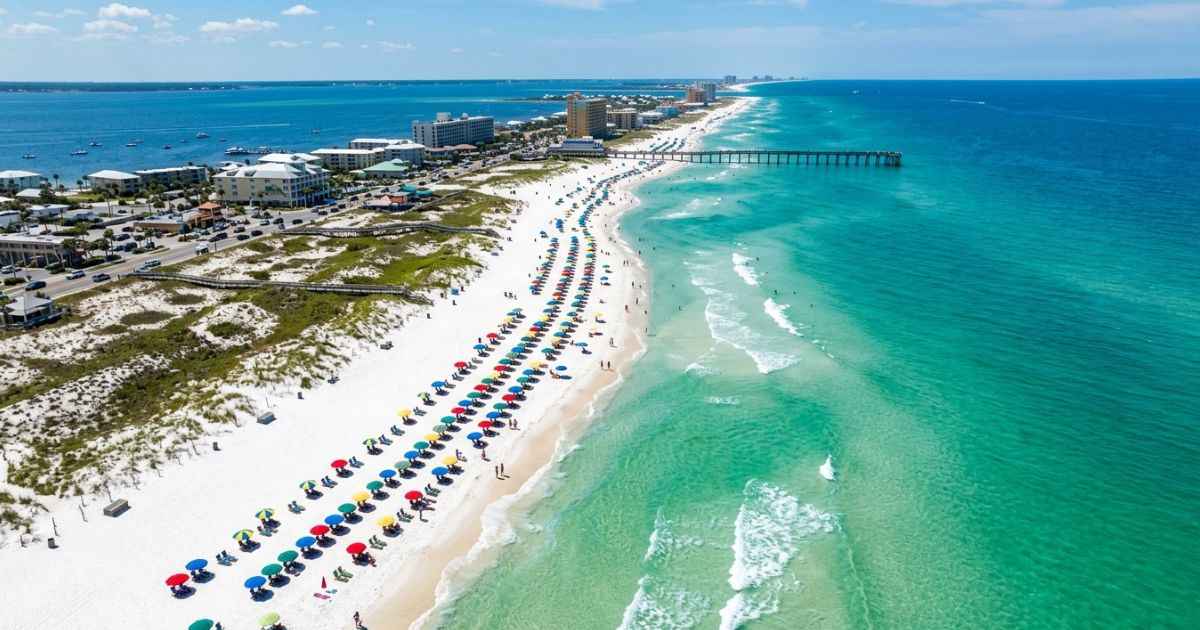 Aerial view of the white-sand shoreline and emerald water at Pensacola Beach, Florida.